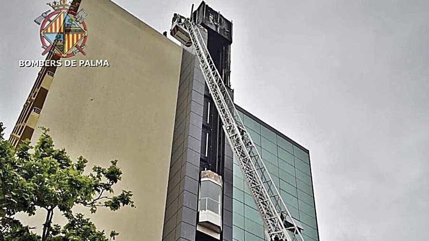 Los bomberos retiran una letra del rÃ³tulo del hotel.