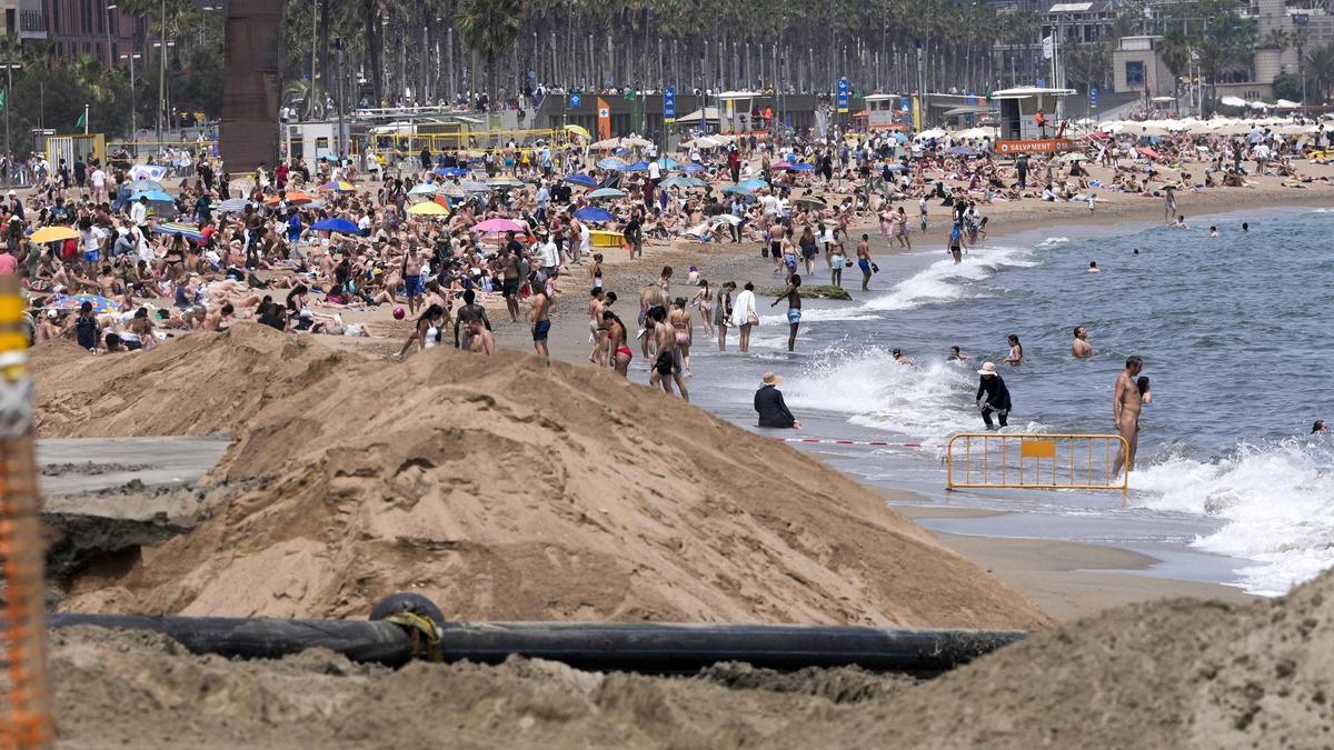 Obras para reponer arena en la playa de Sant Sebastià, en Barcelona.