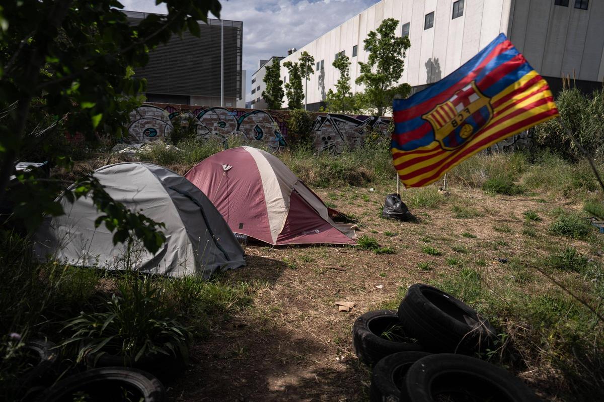 Tiendas de campaña y una bandera del Barça en un descampado del polígono Pedrosa de L'Hospitalet de Llobregat.