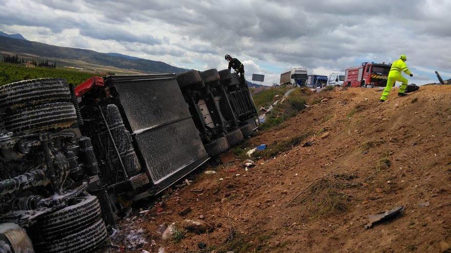 El camión, volcado en el terraplén.