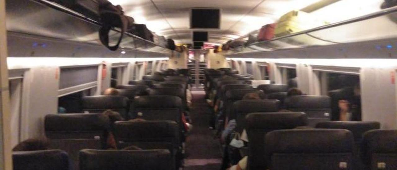 Viajeros a bordo del tren S-103 de Renfe tras ser transbordados desde el Avlo averiado en Sants, este domingo