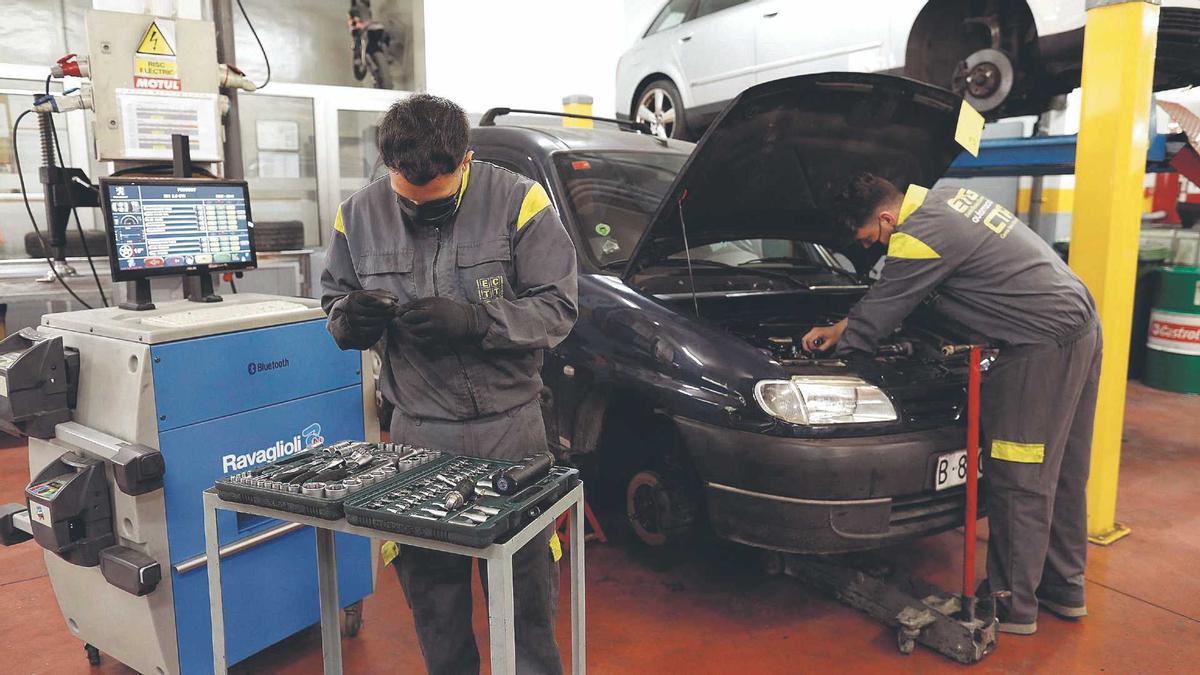 Dos joves reparant un vehicle a l'escola ETG Racing de Girona, en una imatge d'arxiu.