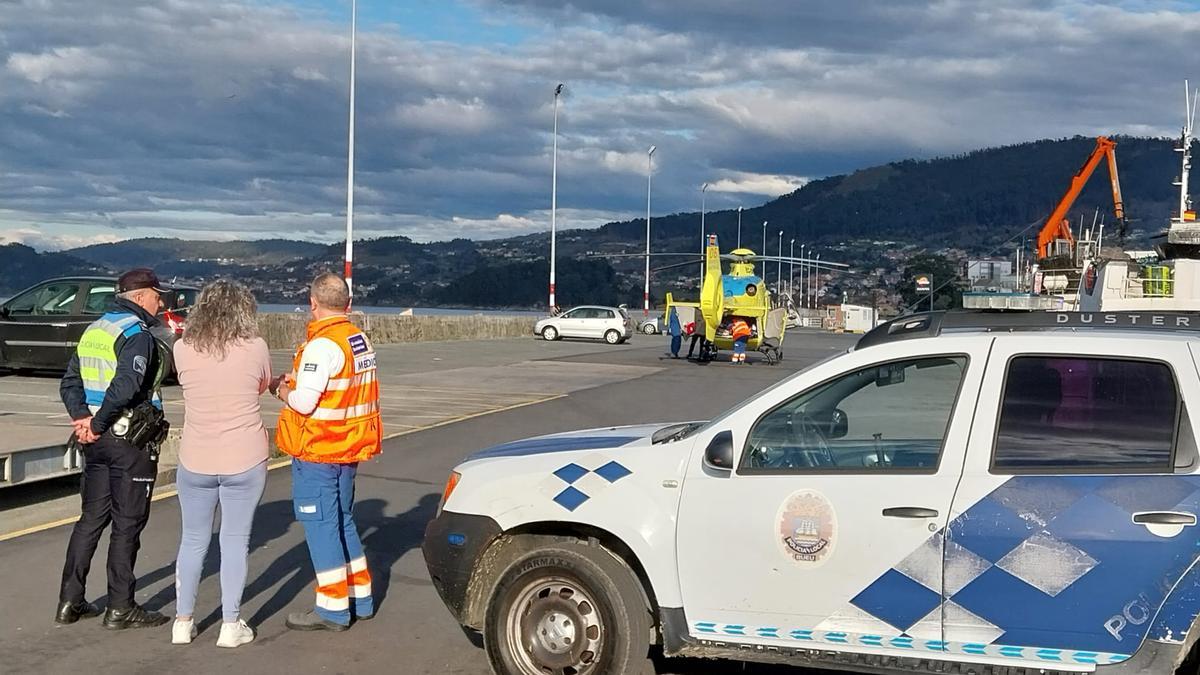 La Policía Local, médicos del 061 y familiares del herido esta tarde en el espigón de Bueu, justo antes de que el helicóptero despegase hacia A Coruña.