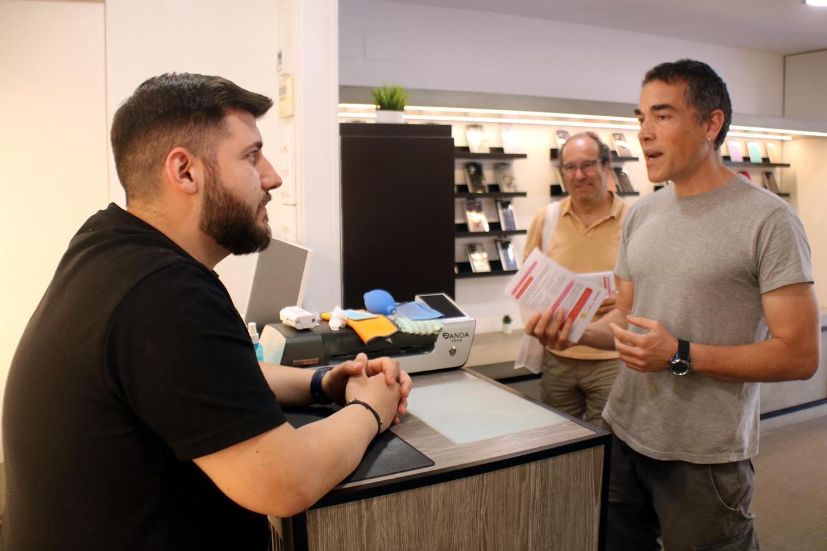 Un dels voluntaris de Plataforma per la Llengua repartint la informació sobre la campanya 'Bon dia!' a un establiment de Girona.