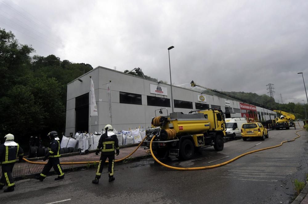 Los bomberos sofocan un incendio en una empresa de neumáticos del polígono langreano de La Moral