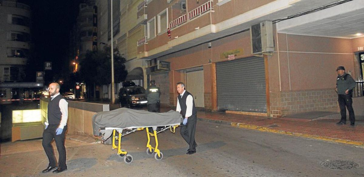Imagen del traslado de uno de los tres cuerpos hallados en la vivienda.