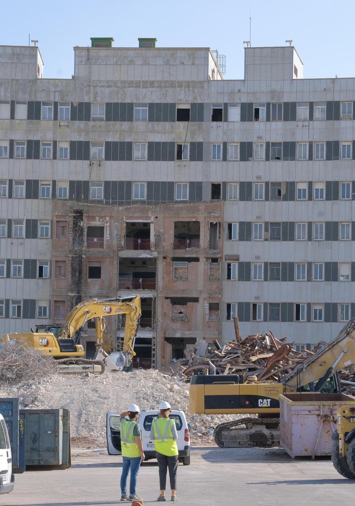 Dos operarios contemplas los trabajos de derribo de los anexos del edifico semicircular