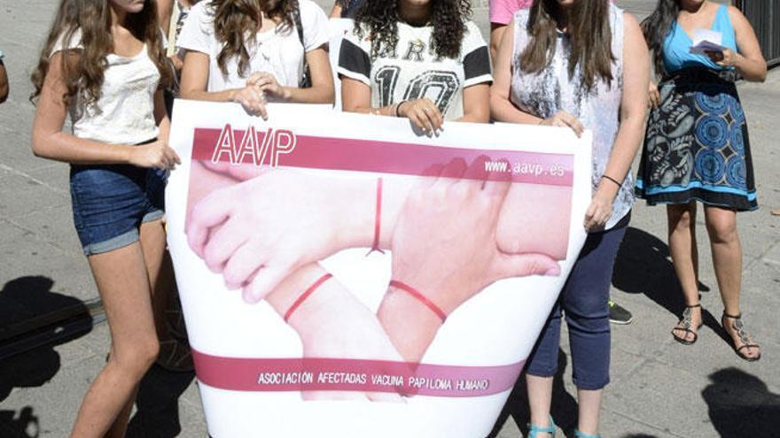 Varias niñas sostienen una pancata de la Asociación de Afectadas por la Vacuna del Papiloma Humano.