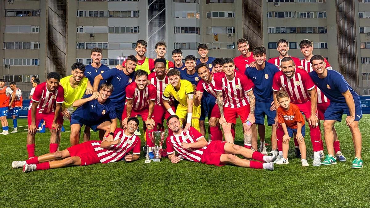 La plantilla manresana, amb el trofeu damunt la gespa del Nou Sardenya