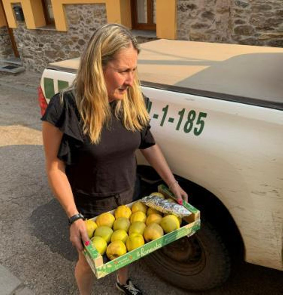 Rosi, vecina de Fasgar, con varias manzanas para repartir entre el dispositivo que trata de controlar el fuego de Fasgar.