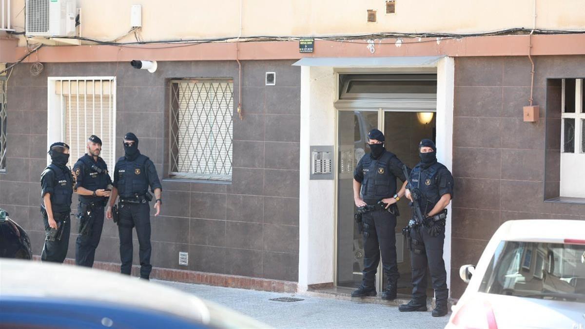 Miembros los mossos custodian la entrada de la vivienda del agresor