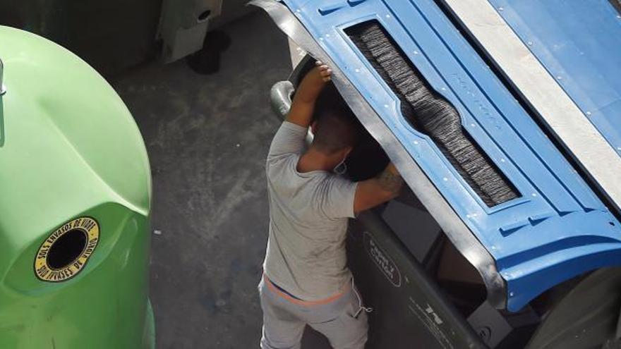 Un hombre buscando en la basura.