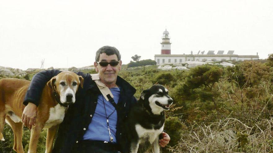 Julio Vilches y sus dos perros; y al fondo, el faro de Sálvora, su hogar durante 37 años.  // J.V.