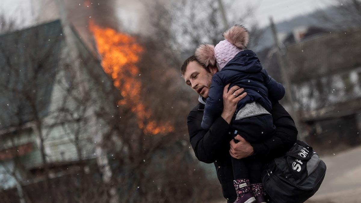 Un hombre y su hijo escapan de la ciudad de Irpin, huyendo de los intensos bombardeos que han caído en la ciudad, en la única ruta de escape que tenían los locales.