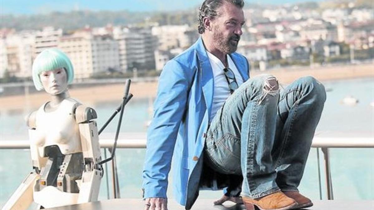 Antonio Banderas posa, antes de presentar su película 'Autómata', con el robot Cleo, en San Sebastián.