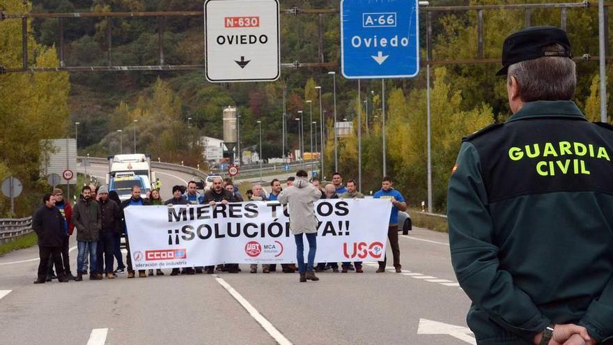 Los trabajadores, ayer, cortando la carretera.