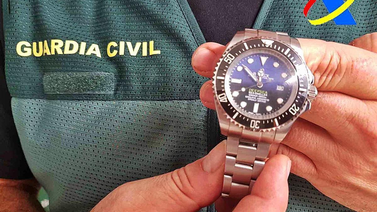 Ein Beamter der Guardia Civil mit einer gefälschten Uhr, die am Flughafen von Palma konfisziert wurde