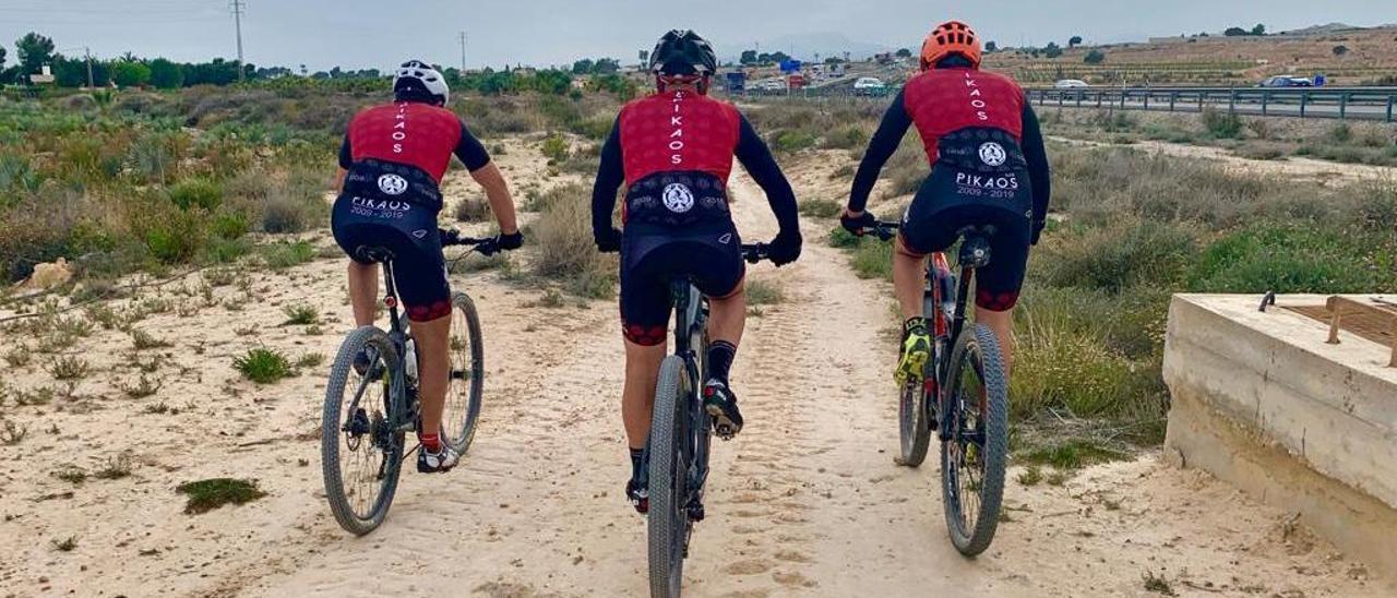 Ciclistas practicando deporte por un camino de Elche.