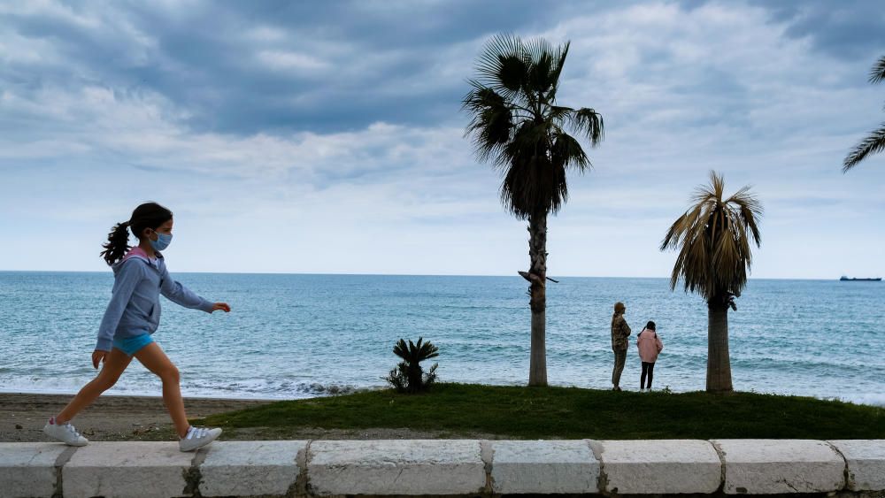 Padres e hijos aprovechan el primer día del desconfinamiento parcial de los niños menores de 14 años para dar un paseo por calles y plazas del Centro de Málaga. En la playa, algunos pequeños aprovechaban para remojarse los pies, bordeando una de las prohibiciones de esta nueva medida.