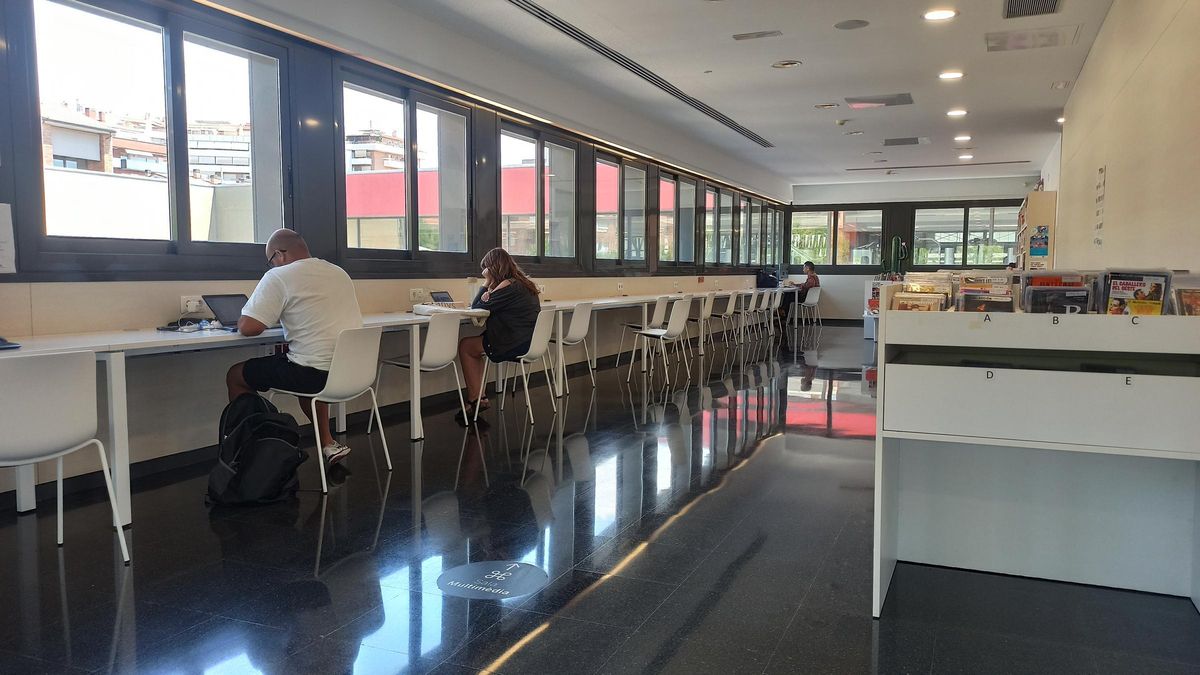 Tres usuaris de la biblioteca de l’Ateneu Les Bases aprofitant fins al darrer minut el temps a l’equipament