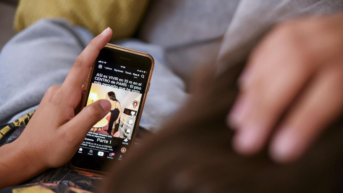 Un adolescente, mirando un vídeo en su móvil.
