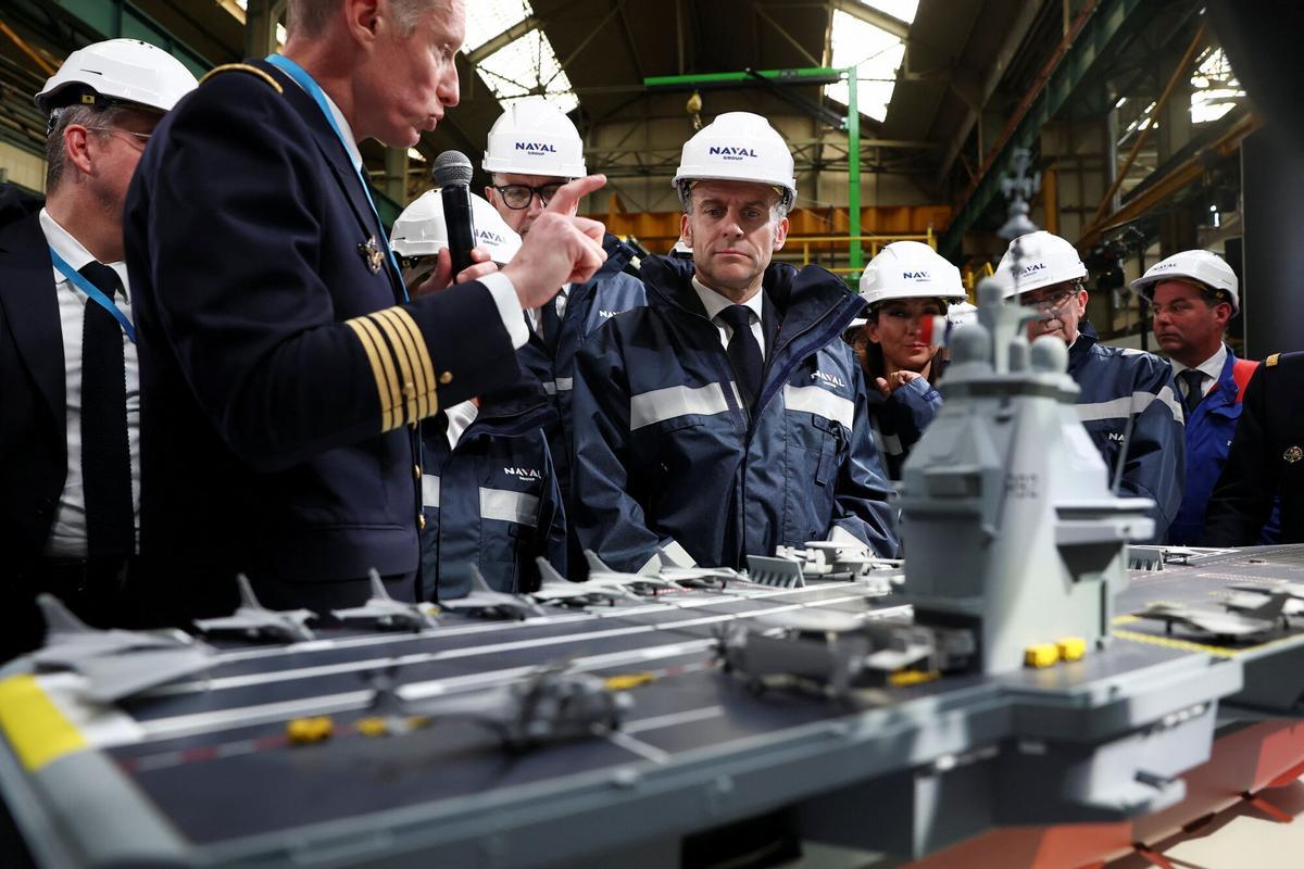 El presidente francés Emmanuel Macron (C) observa un modelo de un portaviones 'France Libre' durante su visita a las instalaciones de construcción de Naval Group Nantes-Indret, donde se está construyendo el próximo portaviones francés, en el oeste de Francia, 18 de marzo de 2026. (Francia) EFE/EPA/GONZALO FUENTES / POOL MAXPPP OUT. MAXPPP OUT
