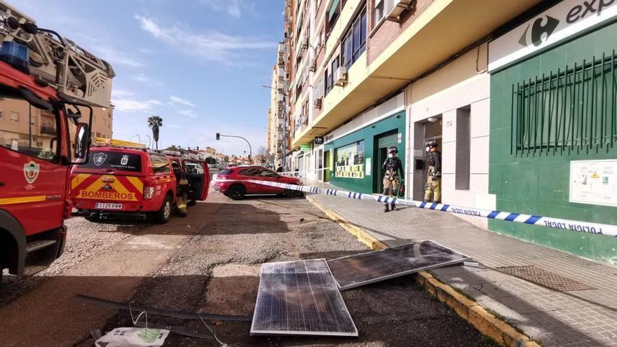 Los bomberos retiran placas solares de un edificio de la autopista tras caer algunas a la calle