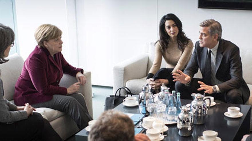 Merkel y el matrimonio Clooney durante su reunión.