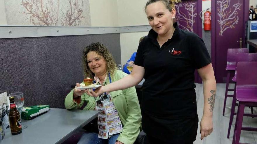 Anuska Álvarez sirve a Úrsula Rodríguez el pincho &quot;Explosión del mar&quot;, elaborado en el café El Sitio.