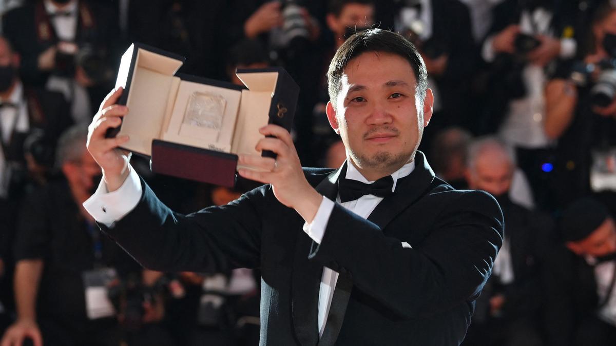 TOPSHOT - Japanese director Ryusuke Hamaguchi poses with his trophy during a photocall after he won the Best Screenplay prize for the film &quot;Drive My Car&quot; during the closing ceremony of the 74th edition of the Cannes Film Festival in Cannes, southern France, on July 17, 2021. (Photo by CHRISTOPHE SIMON / AFP)