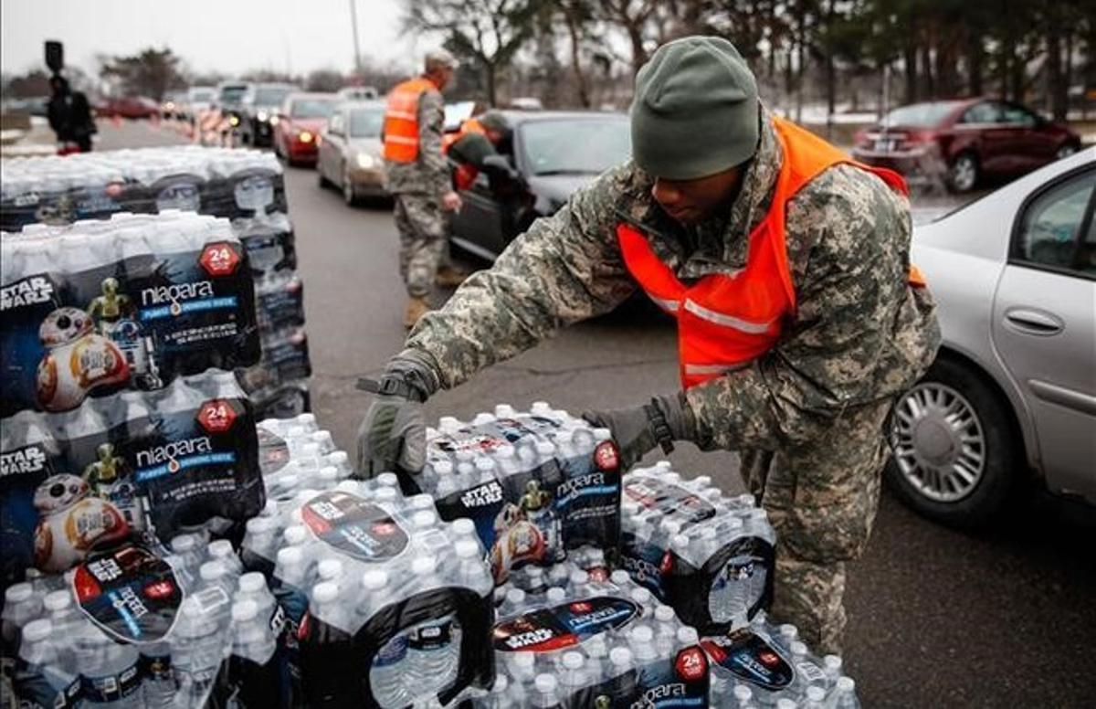 Efectivos de la Guardia Nacional reparten agua embotellada a los habitantes de Flint.