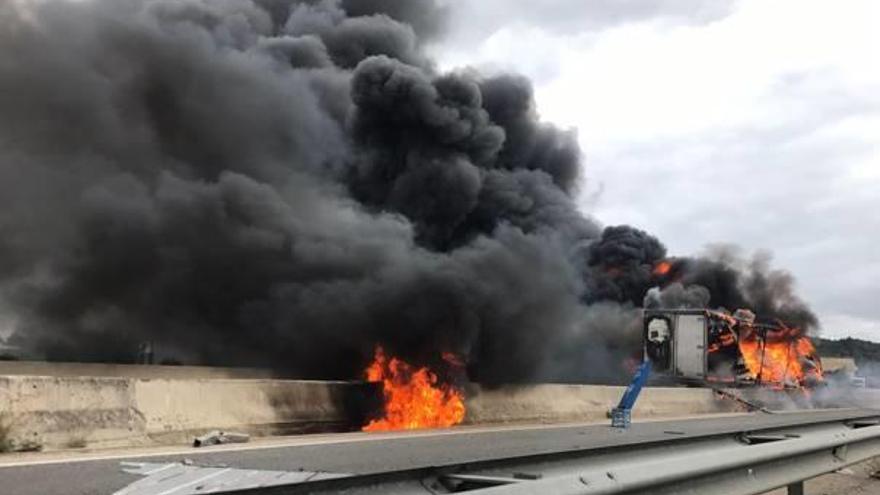 El tráiler que transportaba bobinas de hilo, en llamas, tras la colisión por alcance en la A-7.