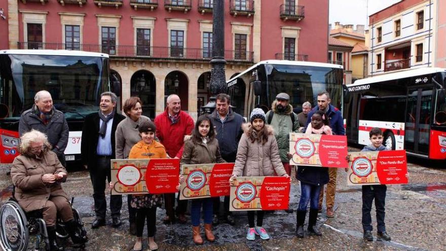 Los niños premiados posan con las autoridades ante los autobuses municipales a los que han dado nombre, ayer, en la plaza Mayor.