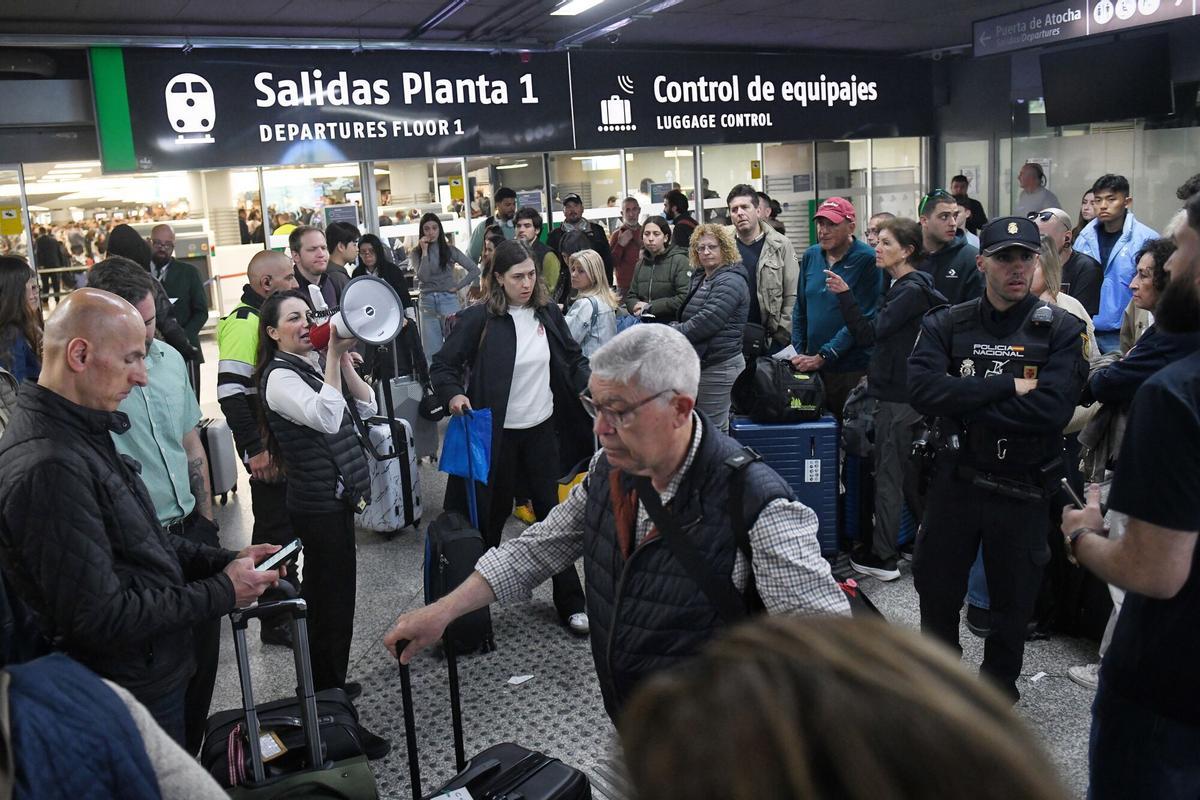 Una trabajadora con un megáfono en la estación de Atocha