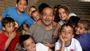 El pare Manel rodeado de niños a los que atendía en Nou Barris, en el 2004.