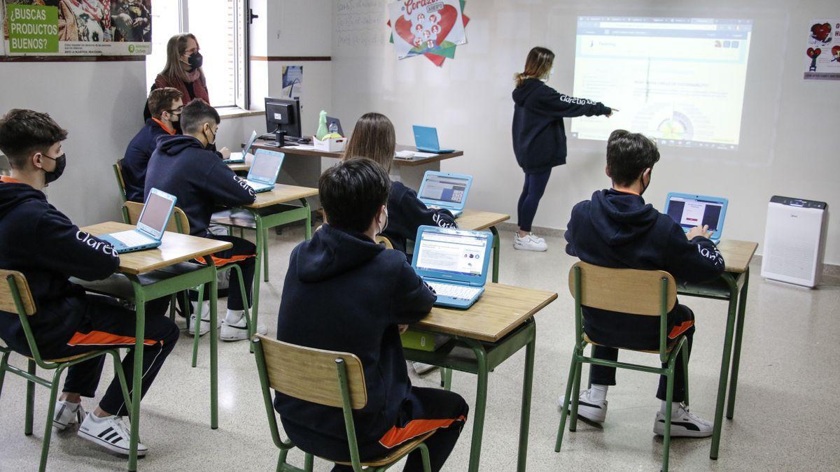 Un grupo de escolares con sus ordenadores en una clase.