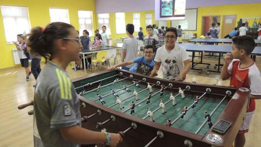 Varios niños juegan al futbolín.