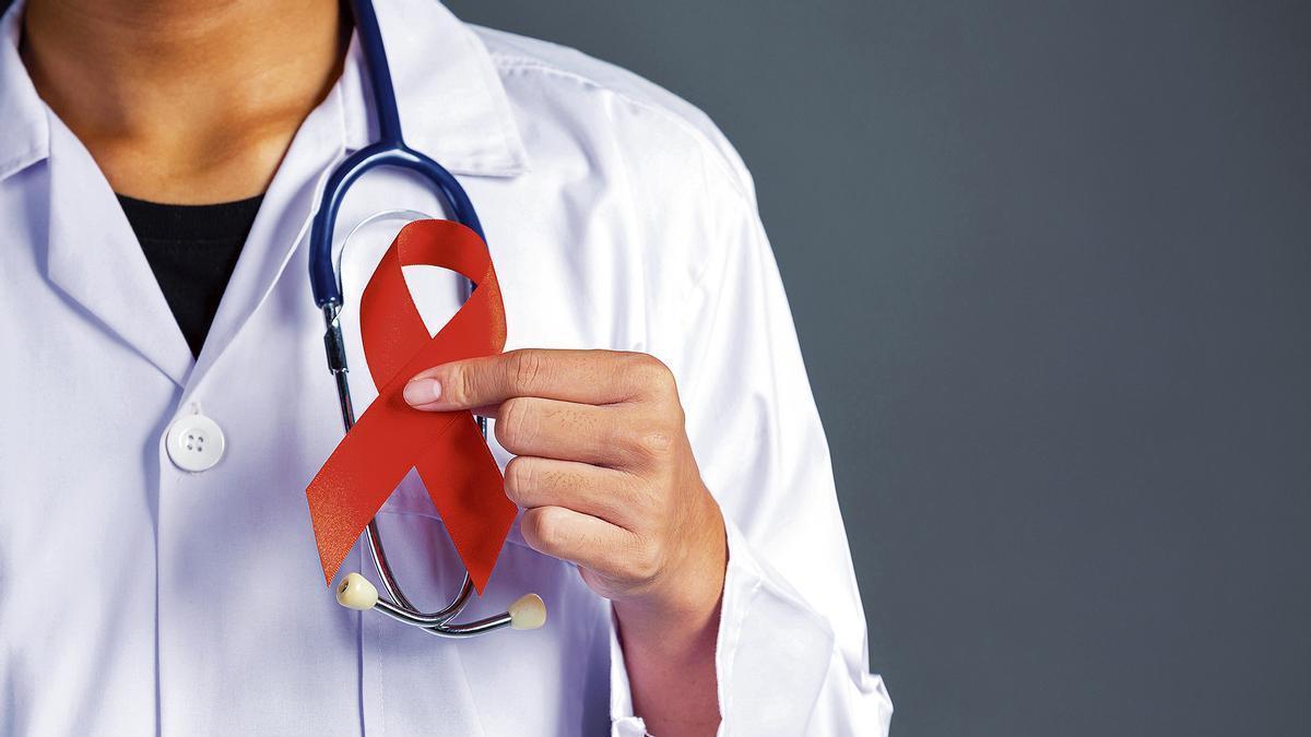 Un médico sosteniendo una cinta contra el cáncer.
