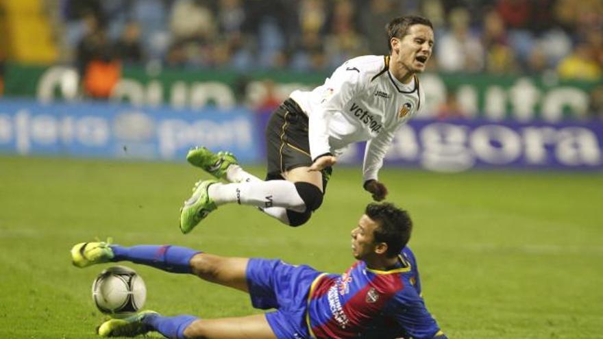 Piatti vuela por el aire
tras una entrada de 
Botelho, que debutó ayer 
con el Levante.