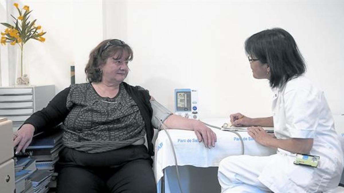 CONTROL DE LA HIPERTENSIÓN. La enfermera del servicio de Nefrología del Hospital del Mar Tai-Mooi Ho, toma la presión a una paciente.