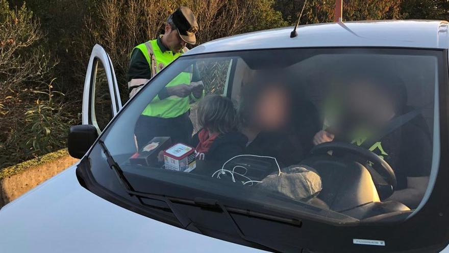 Un niño en el asiento delantero de un vehículo sin silla de retención infantil