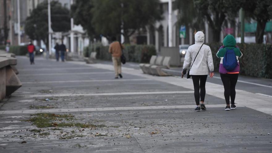 Varias personas, con prendas de abrigo, en el paseo marítimo de A Coruña.