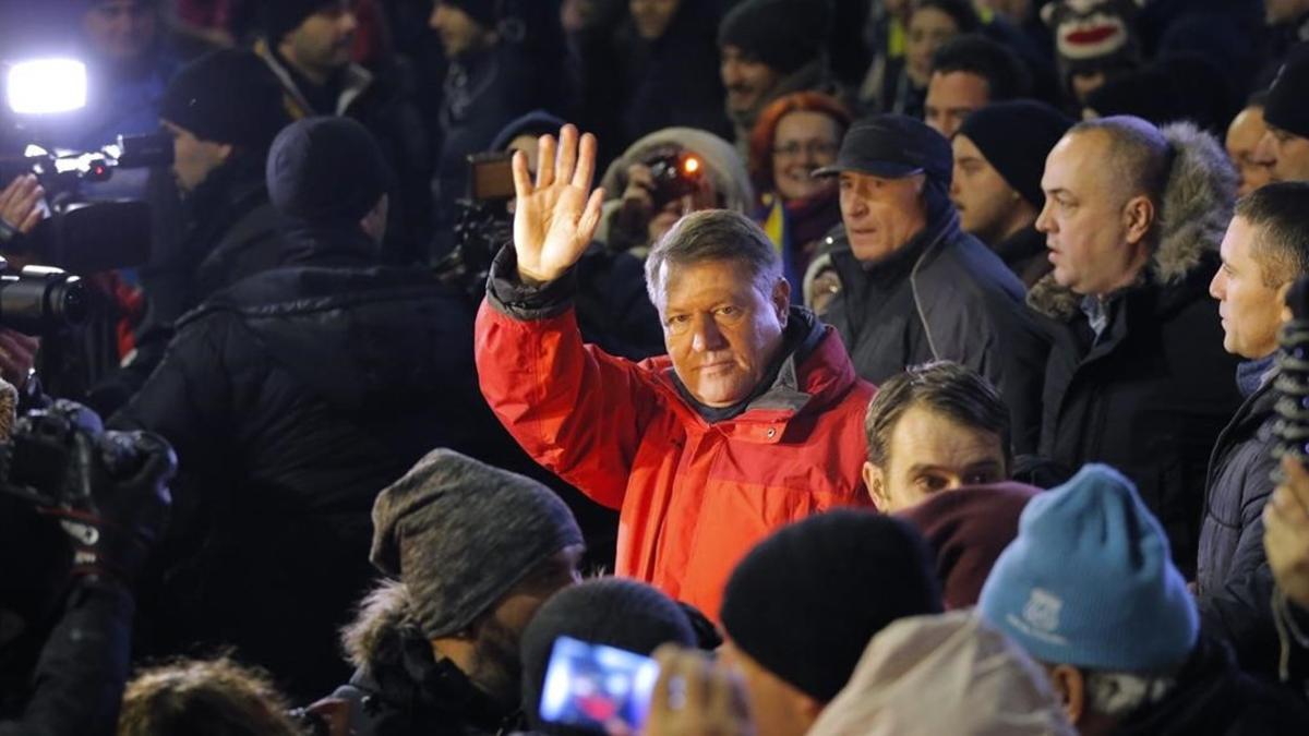 Klaus Iohannis (centro) saluda a los manifestantes en una concentración contra el Gobierno, en Bucarest, el 22 de enero.