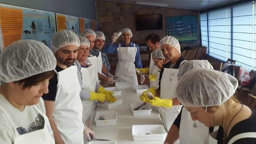 Alumnos del curso de pescadería limpiando doradas. // D.P.