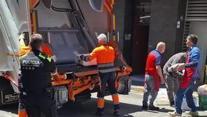 Agentes de la Policía Local de Santa Coloma y operarios de limpieza municipales tiran a la basura alimentos en mal estado o sin etiquetar de un local precintado