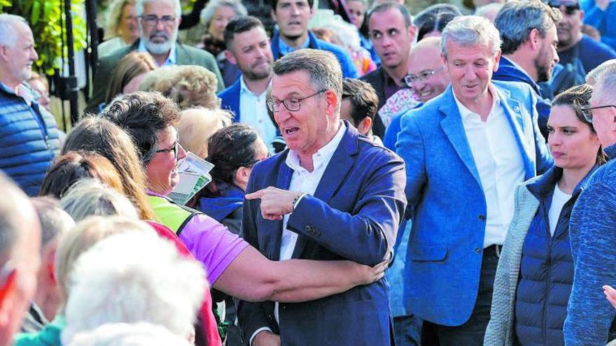 Feijóo, en el centro y con Rueda detrás, saluda a una simpatizante antes de ofrecer un mitin en Ferrol. |   // KIKO DELGADO