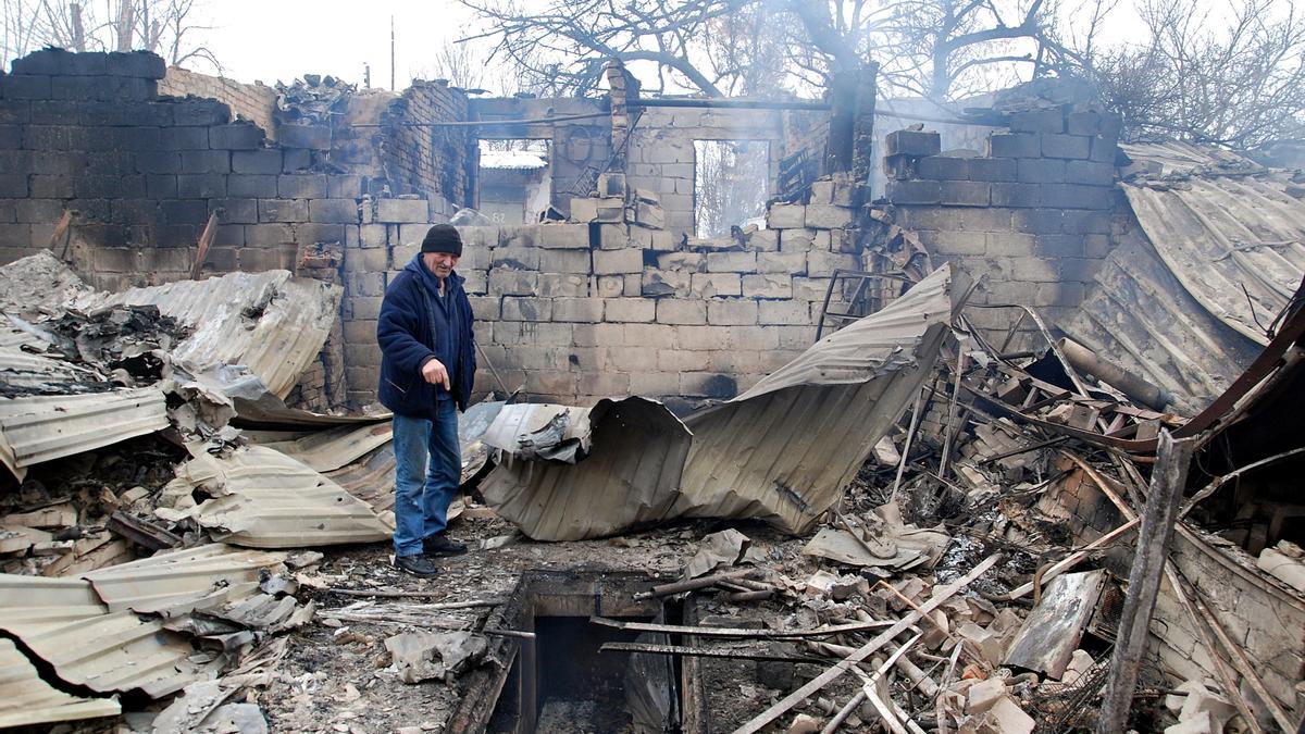 Un hombre señala los efectos de un bombardeo en Járkov.