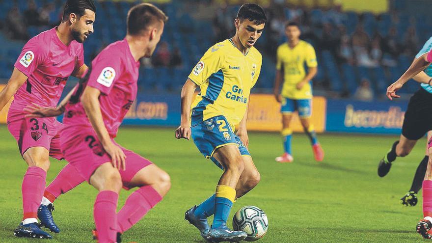 Pedri, rodeado de rivales, en un lance del choque UD Las Palmas-Málaga, el último disputado por lo amarillos en casa, el 28 de febrero.