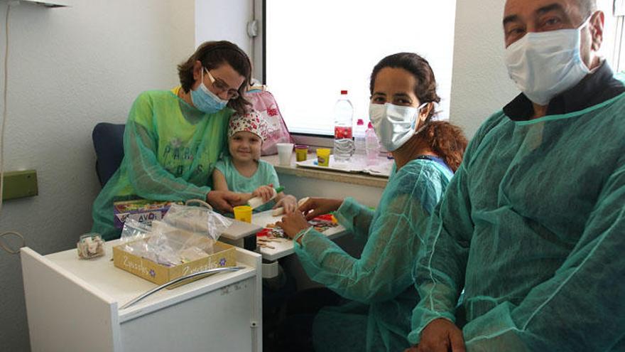 La pequeña Alma, hospitalizada en el Materno Infantil, junto a su madre Rolam y los creadores de Apainf.