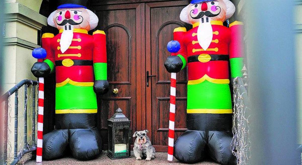 Un perro a las puertas de una casa de Gijón decorada con motivos navideños. | Efe / Paco Paredes